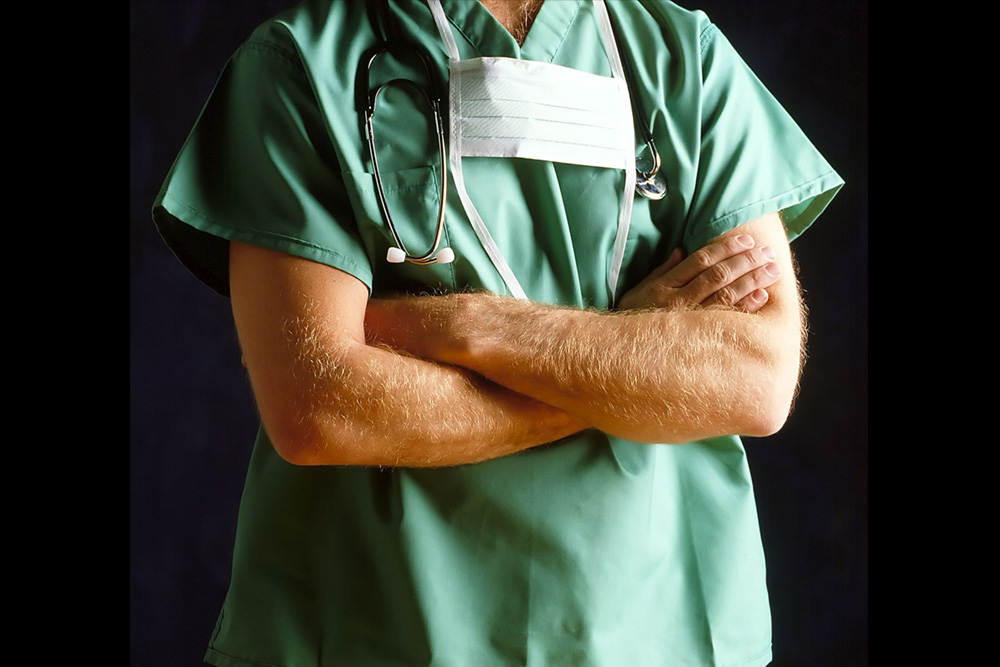 A surgeon's arms folded